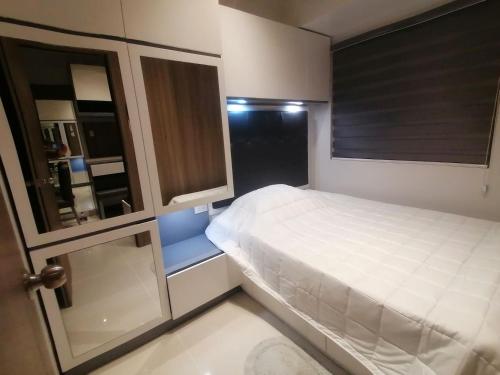 马尼拉Cosy Luxy Coast Residences Staycation的一间小卧室,配有白色的床和窗户