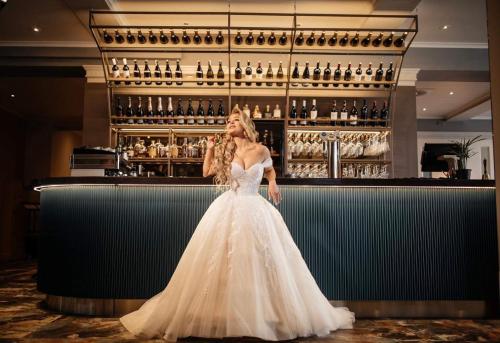 克莱佩达MERCURE HOTEL KLAIPEDA CITY, Conference, Restaurant & Bar - Accor Group的站在酒吧的身着婚纱的女人