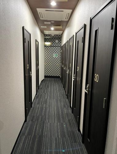 横须贺市Fujiko Building 3F - Vacation STAY 35722v的走廊上设有黑色门和长过道