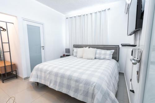 多拉多Aquaville Dorado Moderna Villa 4的一间白色卧室,配有床和电视