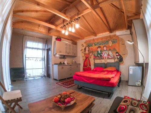 巴统Batumi Wonderland Guest House的木制客房内的一张红色床