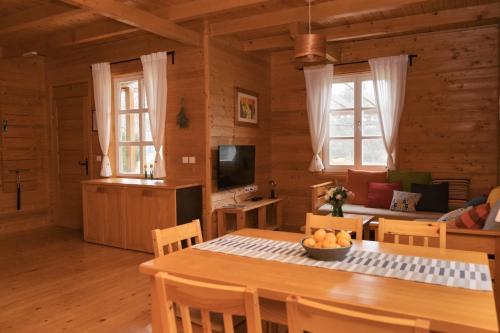 拉科维察Holiday Homes Vita Natura的厨房以及带桌椅的起居室。
