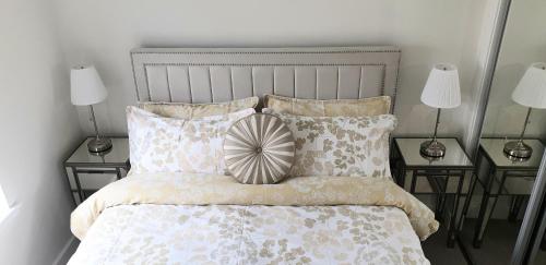 多诺赫Luxurious First Floor Flat的一间卧室配有一张带枕头的床和两盏灯。