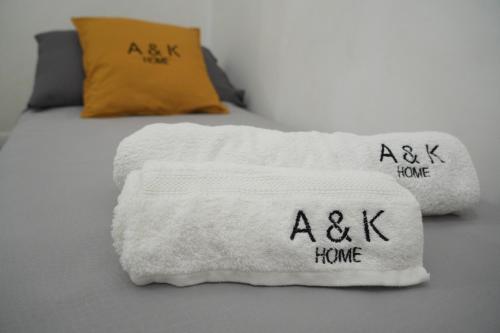 切列梅萨皮卡A&K HOME的一张带白色毛巾的床,带单词 ⁇ 子