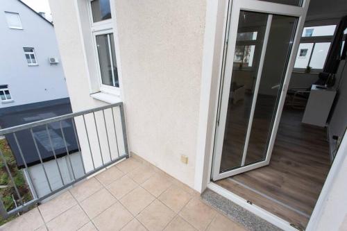 开姆尼茨Schickes 1-Raum-Apartment mit Balkon und vollausgestatteter Küche的大楼内带玻璃门的阳台