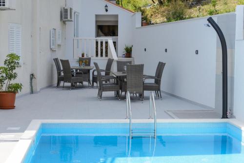 察夫塔特宾果别墅酒店的一个带桌椅的庭院和一个游泳池