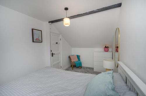 布里斯托Hideaway Cottage的白色卧室配有床和椅子