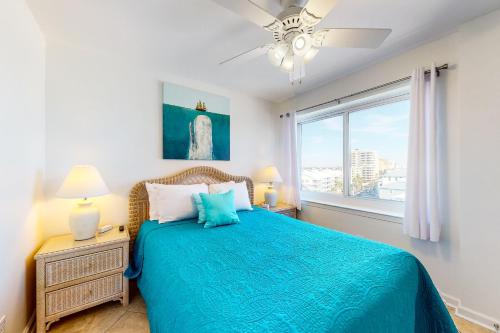 奥兰治比奇Tradewinds 601的一间卧室设有蓝色的床和窗户。