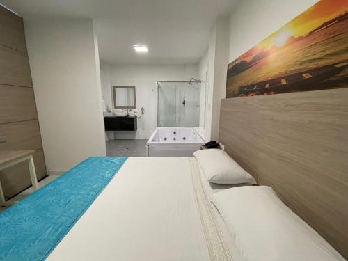 弗洛伦西亚HOTEL G22 COLECTION的一间卧室设有一张大床和一个浴缸