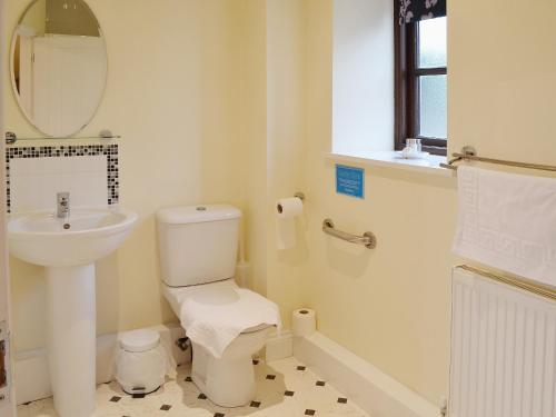 High Halstow马厩小屋的白色的浴室设有水槽和卫生间。