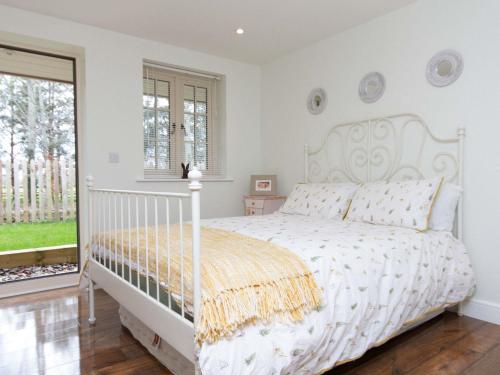 Hockwold cum WiltonBreckland Cottage的白色的卧室设有白色的床和窗户。