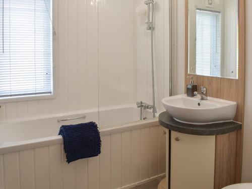 DollarDevin Lodge的白色的浴室设有水槽和浴缸。