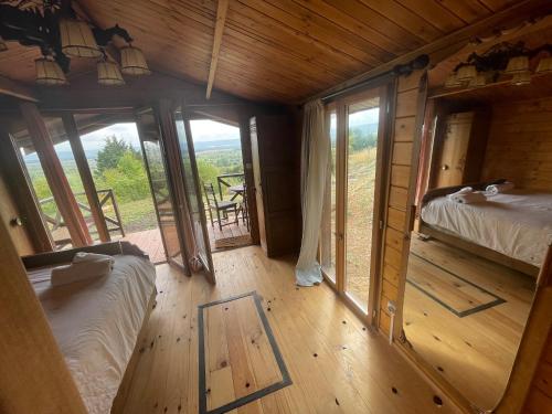 Marais-Vernier7eme ciel - Tiny House avec Grande Piscine intérieure chauffée toute l'année的带窗户的小木屋内,设有两张床。