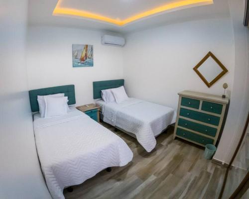 马查利亚Hermosa Casa de Playa Machalilla的一间设有两张床和梳妆台的房间