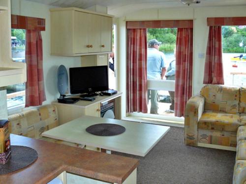 JabelHouse Boat Jabel的客厅配有电视和桌椅
