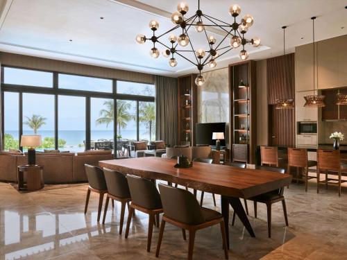 富国Mövenpick Villas & Residences Phu Quoc的用餐室以及带桌椅的起居室。
