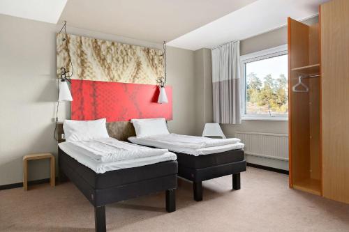 斯德哥尔摩Sure Hotel by Best Western Spånga的客房设有两张床和窗户。