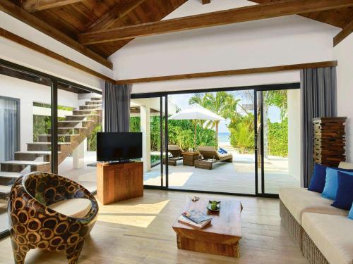 马纳杜岛Mӧvenpick Resort Kuredhivaru Maldives的带沙发和电视的客厅