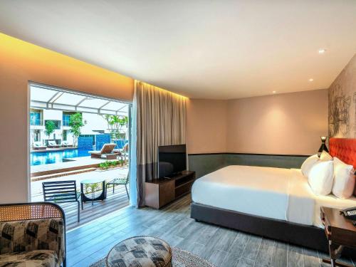 珍南海滩Mercure Langkawi Pantai Cenang的酒店客房设有一张床和一个阳台。
