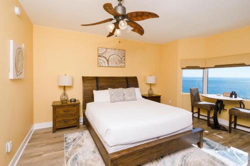 巴拿马城海滩Tidewater2808的一间卧室配有一张带吊扇的床和一张书桌。