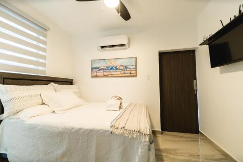 林康Casa Sofía, Aventura Romántica en Rincón的卧室配有白色的床和电视