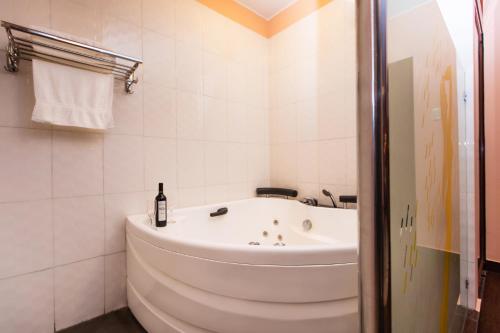 利马La Primacía的带浴缸的白色浴室和一瓶葡萄酒