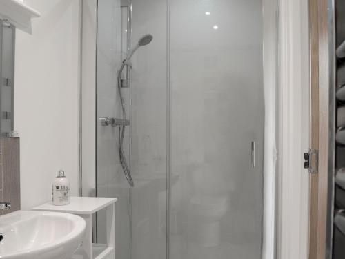InverBarn Owl Cottage的带淋浴和盥洗盆的白色浴室