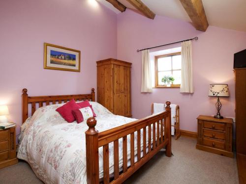 Hazlehead BridgeBramble Cottage - Uk4186的一间卧室设有一张木床和一个窗户。