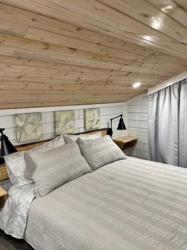 霍姆斯泰德Maria's Tiny Barn的卧室配有白色床和木制天花板