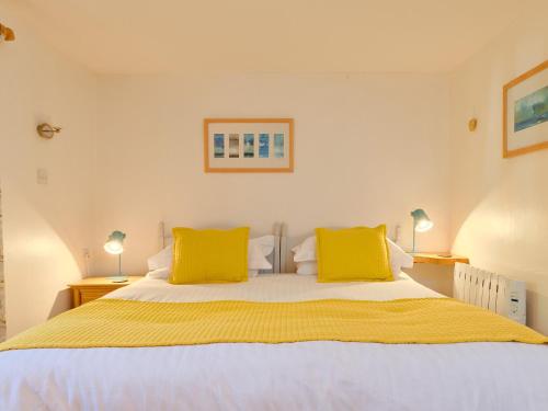 NancledraThe Barn - Ukc4055的一间卧室配有一张带黄色枕头的大床