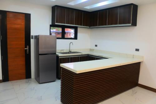 克拉克Aurora Villas and Cabin Resort的厨房配有木制橱柜和不锈钢冰箱。