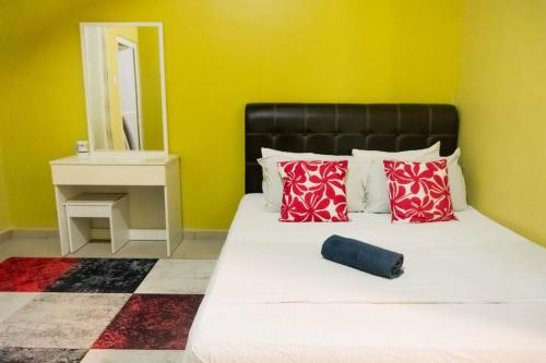 汝来5 Bedrooms Homestay with Private Pool (SEROJA)的一间卧室配有一张带红色枕头和镜子的床