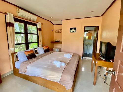 湄宏颂巴普哈多尔酒店的一间卧室配有一张带电视和书桌的床。