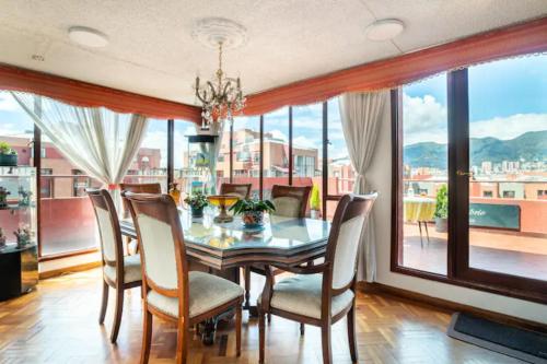 波哥大Habitaciones en un alojamiento -Anfitrion - Elias Di Caprio的一间带桌椅和大窗户的用餐室
