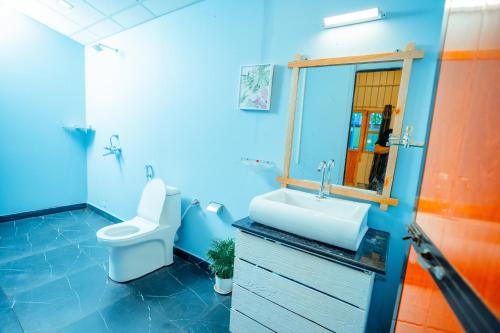 阿贡达orange sky beach bungalow的蓝色的浴室设有卫生间和水槽