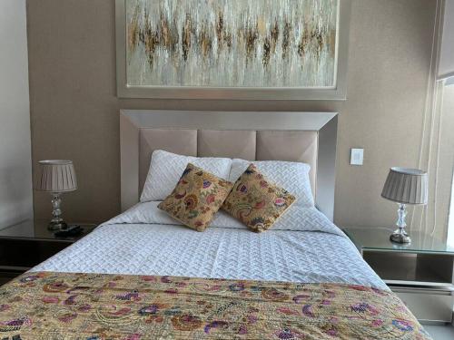 巴兰基亚Rams apartasuits en hotel 5 estrellas的卧室内的一张带两个枕头的床