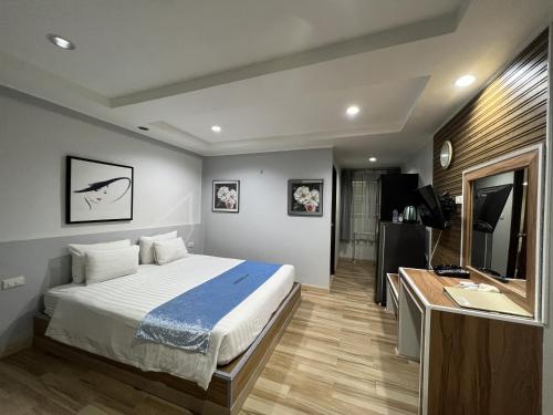 芭堤雅市中心芭堤雅海滨度假酒店的一间卧室配有一张床、一张书桌和一台电视