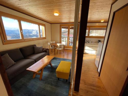 野沢Tamanegi House luxury 4 bedroom Ski Chalet的客厅配有沙发和桌子