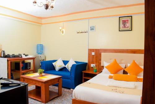 奈瓦沙Shalom Apartments的酒店客房,配有床和蓝色的沙发