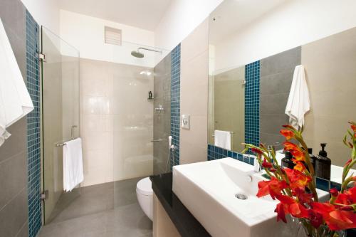 尼甘布The Beach Apartments的一间带水槽、卫生间和镜子的浴室