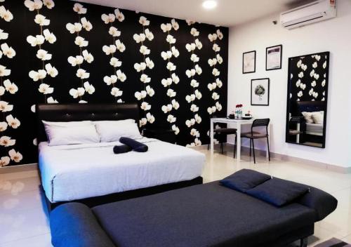 实达阿南Peanut Butter Homestay #Trefoil Setia City的卧室配有带白色鲜花的黑色墙壁