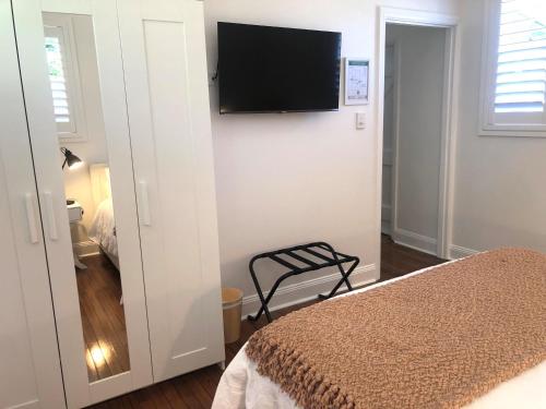 阿米代尔The Stables的卧室配有一张床和壁挂式平面电视。
