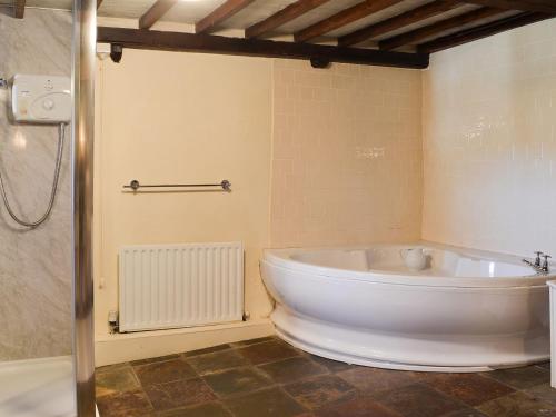 埃斯克代尔Birkerthwaite Barn-w41478的带淋浴的浴室内的白色大浴缸