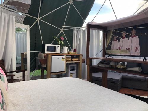 汉密尔顿Flowerhaven - glamping dome的一间卧室设有帐篷,其中配有电视