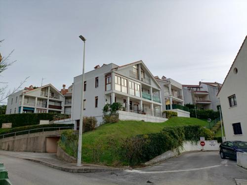 莫格罗Precioso apartamento con piscina en la playa的草山顶上一座白色的大房子