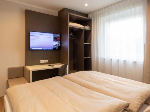 弗尔克马克特Jagerwirt rooms的一间卧室配有一张床和一台平面电视