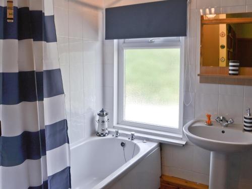 Heddon on the WallIsabella Cottage的带浴缸、水槽和窗户的浴室