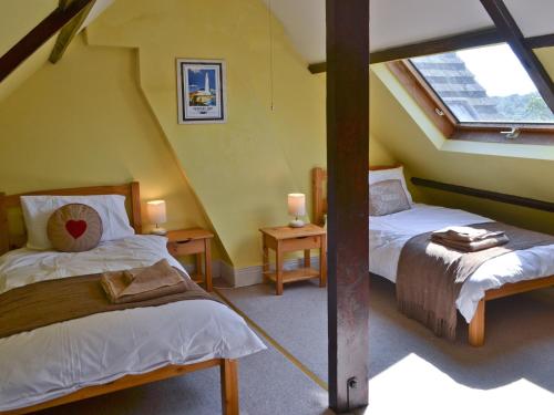 Heddon on the WallIsabella Cottage的阁楼卧室设有两张床和窗户。