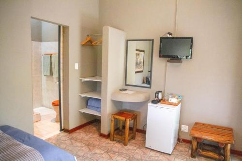 GroblersbrugKlippan River Lodge的一间带水槽和卫生间的浴室以及一台电视。