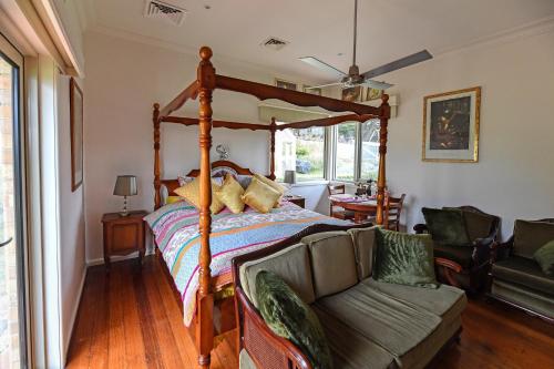 吉斯伯恩Galahad's Animal Sanctuary B&B的一间卧室配有天蓬床和沙发